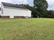 Spacious backyard showcasing a large, well-maintained lawn, brick foundation, and rear building exterior at 6 Boxley Dr, Wendell, NC 27591