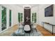 Elegant dining room with modern lighting, dark wood table, and backyard views at 6701 Green Hollow Ct, Wake Forest, NC 27587