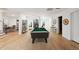 Spacious game room featuring a pool table, hardwood floors, and ample seating for entertaining guests at 6701 Green Hollow Ct, Wake Forest, NC 27587