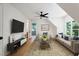 Cozy living room with high ceilings, hardwood floors, comfortable seating, and a large tv screen at 6701 Green Hollow Ct, Wake Forest, NC 27587