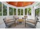 Relaxing sunroom with wood-paneled ceiling, serene views, and comfortable seating at 6701 Green Hollow Ct, Wake Forest, NC 27587