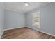 This bedroom features light blue walls, wood floors, a ceiling fan, and a window at 74 Dove Trl Trl, Sanford, NC 27332