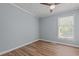This bedroom features light blue walls, wood floors, a ceiling fan, and a window at 74 Dove Trl Trl, Sanford, NC 27332