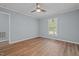This bedroom features light blue walls, wood floors, a ceiling fan, and a window at 74 Dove Trl Trl, Sanford, NC 27332
