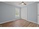 This bedroom features light blue walls, wood floors, a ceiling fan, window, and closet at 74 Dove Trl Trl, Sanford, NC 27332