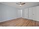 This bedroom features light blue walls, wood floors, a ceiling fan, closet, and doors at 74 Dove Trl Trl, Sanford, NC 27332