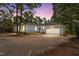 Charming single-story home featuring a two-car garage and a gravel driveway at dusk at 74 Dove Trl Trl, Sanford, NC 27332