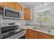 Modern kitchen showcasing stainless appliances, granite counters, undermount sink, and wood cabinetry at 74 Dove Trl Trl, Sanford, NC 27332