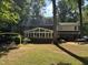 View of the back exterior, featuring a large sunroom and a spacious grassy yard at 7905 Breda Ct, Raleigh, NC 27606