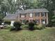 Charming brick two-story home with black shutters, a red front door, and mature landscaping at 7905 Breda Ct, Raleigh, NC 27606