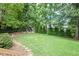Lush backyard featuring mature trees and room for play at 906 Stuart Dr, Mebane, NC 27302