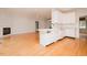 Open-concept living space with fireplace and hardwood floors adjoins kitchen with white cabinets and appliances at 906 Stuart Dr, Mebane, NC 27302