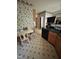 A cozy dining area featuring a dark countertop, wooden cabinets, and floral wallpaper at 9160 Old Cascade Road Dr, Garner, NC 27529
