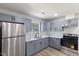 Updated kitchen with grey cabinets, stainless steel refrigerator, and marble countertops at 1020 Benning St, Durham, NC 27703