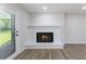 Bright room with wood floors and white brick fireplace with black insert at 1020 Benning St, Durham, NC 27703