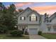 Charming two-story home with white siding, a garage, manicured lawn, and colorful evening sky at 137 Cricketgrass Dr, Cary, NC 27513