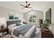 Staged main bedroom with vaulted ceilings, fan, and an arched window overlooking the neighborhood at 137 Cricketgrass Dr, Cary, NC 27513