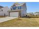 Charming two-story home featuring stone accents, gray siding, a two-car garage, and manicured landscaping at 138 Favored Avenue, Sanford, NC 27330
