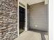 A close-up shot of a stylish black front door with stone and siding accents on the exterior of the home at 138 Favored Avenue, Sanford, NC 27330