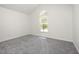 Clean bedroom with grey carpet, white walls, and a window letting in natural light at 220 Needle Park Dr, Cary, NC 27513