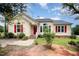 Charming yellow home featuring red shutters, a brick walkway, and a well-maintained front lawn at 220 Needle Park Dr, Cary, NC 27513