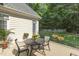 Back patio with table set and manicured landscaping offering a peaceful outdoor retreat at 321 Wescott Ridge Dr, Holly Springs, NC 27540