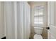 Bright bathroom featuring a shower with curtain and a toilet with a window above at 321 Wescott Ridge Dr, Holly Springs, NC 27540