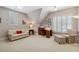 Cozy bedroom with plantation shutters, floral sofa, red pillow, and striped armchair at 321 Wescott Ridge Dr, Holly Springs, NC 27540
