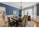 Formal dining room with wainscoting, blue accent wall and elegant chandelier at 321 Wescott Ridge Dr, Holly Springs, NC 27540
