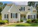 Charming home featuring a brick facade, black shutters, and a beautifully landscaped front yard with a light blue front door at 321 Wescott Ridge Dr, Holly Springs, NC 27540
