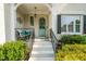 Covered front porch features a cozy bench, a light blue door with a wreath, and freshly painted stairs at 321 Wescott Ridge Dr, Holly Springs, NC 27540