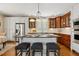 Kitchen with a large island with dark granite countertops, stainless steel appliances, and wood cabinets at 321 Wescott Ridge Dr, Holly Springs, NC 27540