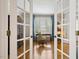View of a home office with hardwood floors, desk, and shuttered windows from a glass doorway at 321 Wescott Ridge Dr, Holly Springs, NC 27540