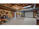 Unfinished basement with exposed ceilings, concrete floors, and garage door at 516 Ivey Rd, Graham, NC 27253