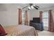 Bedroom featuring a bed with ornate metal frame, ceiling fan, and natural light from the windows at 516 Ivey Rd, Graham, NC 27253