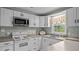 Well-lit kitchen with stainless steel microwave, white cabinets and window view at 516 Ivey Rd, Graham, NC 27253