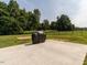 View of the backyard concrete patio and fenced yard with mature trees at 5215 Goshawk Ln, Graham, NC 27253