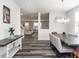 Open-concept dining room with modern chandelier, grey wood floors, and stylish decor at 5215 Goshawk Ln, Graham, NC 27253
