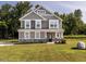 Beautiful two-story home featuring gray siding, stone accents, green lawn and manicured landscaping at 5215 Goshawk Ln, Graham, NC 27253