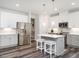Modern kitchen with stainless steel appliances, gray cabinets, and a central island with seating at 5215 Goshawk Ln, Graham, NC 27253