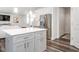 Kitchen island with gray cabinetry, stainless steel appliances, and open floor plan at 5215 Goshawk Ln, Graham, NC 27253