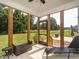 Beautiful screened-in porch with wicker furniture and views of the green backyard at 5215 Goshawk Ln, Graham, NC 27253