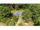 Aerial view of a cozy blue house surrounded by lush greenery and mature trees on a spacious lot at 545 Barnette Rd, Louisburg, NC 27549