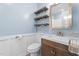 Cozy bathroom featuring wood accents, floating shelves, stylish vanity, and updated mirror at 545 Barnette Rd, Louisburg, NC 27549