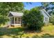 View of the house showcasing the front porch, landscaping, and mature trees at 545 Barnette Rd, Louisburg, NC 27549