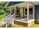 Close-up of a welcoming covered porch with white railings and brick foundation at 545 Barnette Rd, Louisburg, NC 27549