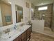 Bathroom with double sinks, marble countertops, and modern tiled shower with glass surround at 555 Hinnant Rd, Selma, NC 27576