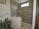 Modern bathroom with tiled shower, glass surround, and vanity with countertop storage at 555 Hinnant Rd, Selma, NC 27576
