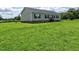 Exterior view of a gray house surrounded by a lush green field at 555 Hinnant Rd, Selma, NC 27576