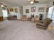 Large living room with carpeted floors, multiple seating areas, and ample natural light at 555 Hinnant Rd, Selma, NC 27576